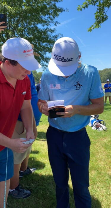 Cam Smith gets Blake Jaros' number after breaking his phone with his tee shot during Round 3 of the 2022 FedEx St. Jude Championship in Memphis, Tennessee.